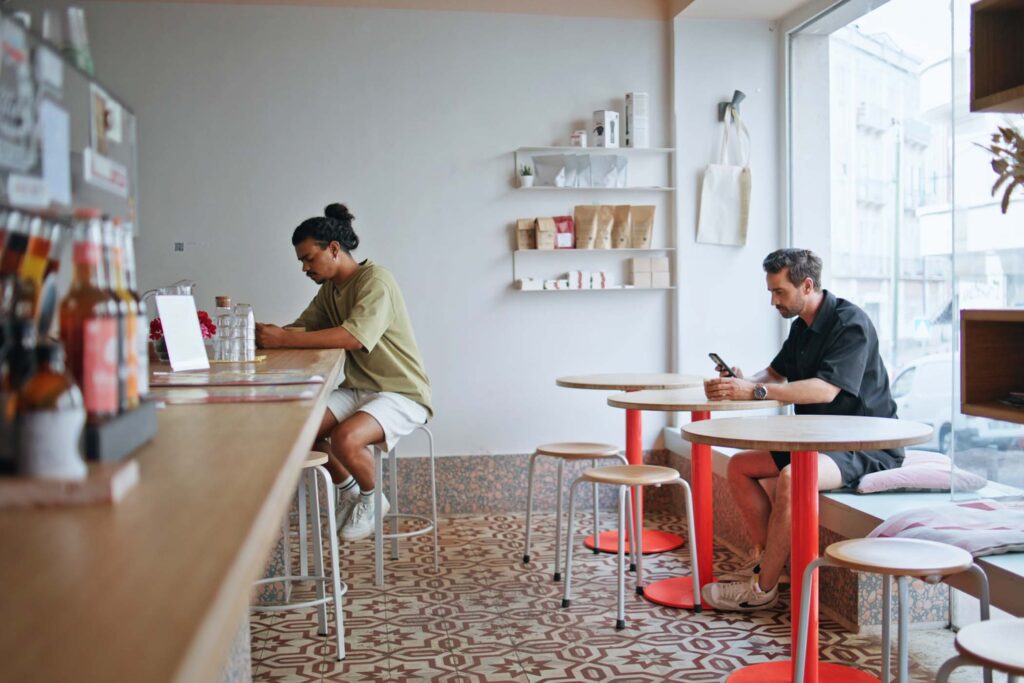 two-coffee-shop-clients-sitting-separately-in-cozy-CXTCH6T.jpg